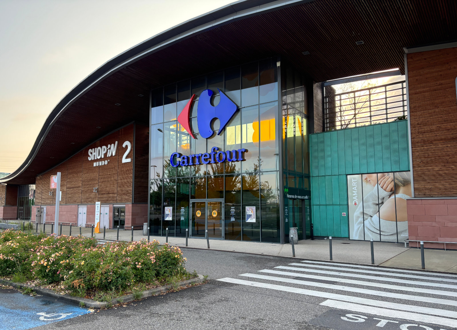 Façade du centre commercial Carrefour Mundolsheim avec entrée principale et architecture contemporaine