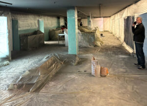 Zone de travaux confinée avec protection plastique pour rénovation intérieure en grande surface