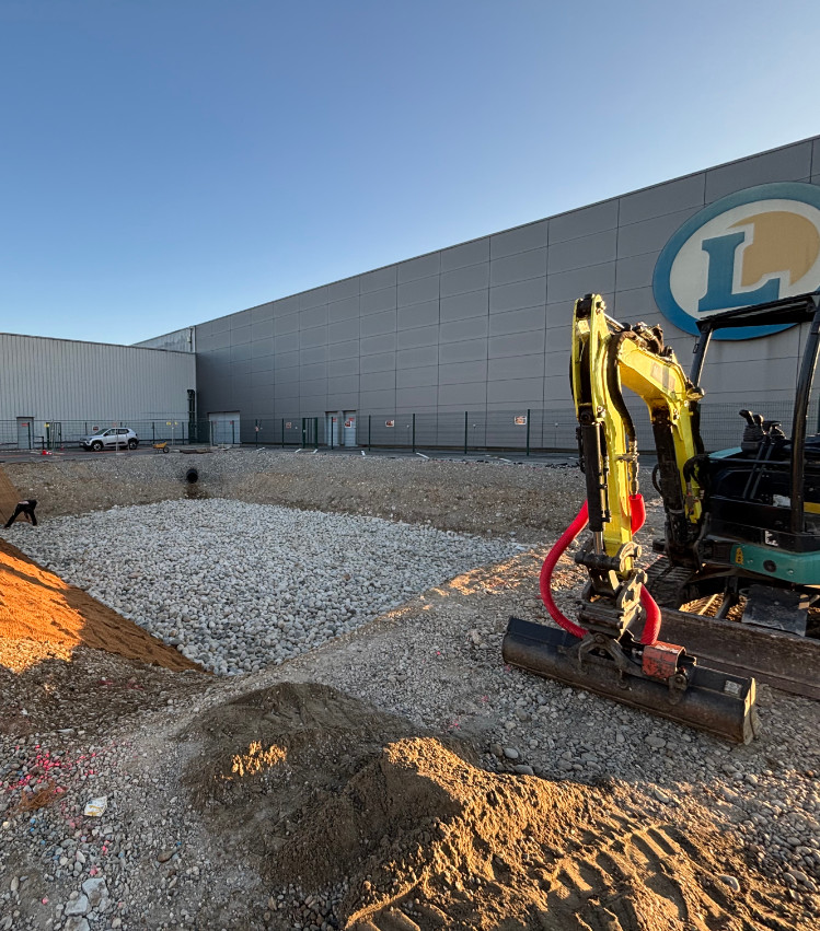 Réalisation d’un bassin d’infiltration des eaux pluviales sur un site commercial ERP, travaux de terrassement et gestion des eaux.